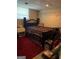 Bedroom with dark wood bed frame, red area rug, and overhead shelving for storage at 268 Rountree Rd, Riverdale, GA 30274