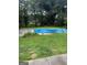 Backyard showcasing a covered in-ground pool, surrounded by green grass and lush trees at 268 Rountree Rd, Riverdale, GA 30274