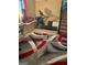 Spacious recreation room with neutral walls, patterned rug, and a treadmill near a window with red and black curtains at 268 Rountree Rd, Riverdale, GA 30274