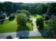 Aerial view of a home with manicured lawn and mature trees in a residential neighborhood at 165 Mcelwaney Way, Fayetteville, GA 30215