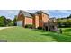 Two-story brick home featuring an attached garage and a spacious grassy yard at 165 Mcelwaney Way, Fayetteville, GA 30215