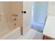 Bright bathroom features a tub with a shower and a white tile floor at 165 Mcelwaney Way, Fayetteville, GA 30215