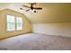 Slanted bedroom with ceiling fan, neutral walls and carpet, and large window at 165 Mcelwaney Way, Fayetteville, GA 30215