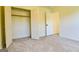 This bedroom features neutral walls and carpet, closet, and doorways leading to other parts of the house at 165 Mcelwaney Way, Fayetteville, GA 30215