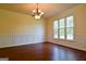 Dining room features hardwood floors, wainscoting, chandelier, and large windows at 165 Mcelwaney Way, Fayetteville, GA 30215