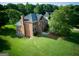 Aerial view of a brick two-story home on a large lot with mature trees at 165 Mcelwaney Way, Fayetteville, GA 30215