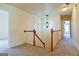 Light-filled hallway with carpet flooring and wooden railing at 165 Mcelwaney Way, Fayetteville, GA 30215