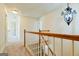 Hallway with hardwood staircase features white walls and a modern chandelier at 165 Mcelwaney Way, Fayetteville, GA 30215