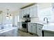 Kitchen showcasing stainless steel appliances, white cabinetry, and hardwood flooring at 165 Mcelwaney Way, Fayetteville, GA 30215