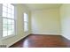 Sunlit living room with hardwood floors, yellow walls, and large windows at 165 Mcelwaney Way, Fayetteville, GA 30215