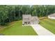 Aerial view of a charming home with a spacious lawn, two-car garage, and mature trees at 132 Whitworth Dr # 15, Locust Grove, GA 30248