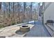 Backyard patio with a built-in stone fire pit, wooded privacy, and deck access at 4203 Harrogate Nw Dr, Atlanta, GA 30327
