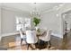 Dining room featuring elegant light fixture, hardwood floors, large window, and neutral tones at 4203 Harrogate Nw Dr, Atlanta, GA 30327