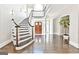 Elegant foyer featuring a curved staircase with dark wood accents, bright light, and beautiful hardwood floors at 4203 Harrogate Nw Dr, Atlanta, GA 30327