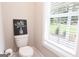 Bathroom featuring a toilet next to a window with plantation blinds at 61 Main St, Moreland, GA 30259