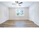 Spacious bedroom with hardwood floors, a modern ceiling fan, and natural light from the window at 61 Main St, Moreland, GA 30259