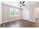 Bedroom features hardwood floors and a ceiling fan, with a view of the bathroom and door to hall at 61 Main St, Moreland, GA 30259