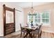 Cozy dining area featuring a barn door, modern chandelier, and window view at 61 Main St, Moreland, GA 30259