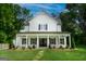 Charming two-story white farmhouse with a manicured lawn and landscaped front yard with stone path at 61 Main St, Moreland, GA 30259