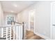 Hallway with hardwood floors and wooden handrail, leading to a bathroom, and bedroom with a view at 61 Main St, Moreland, GA 30259