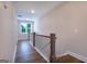 Bright hallway featuring hardwood floors, a window and stylish wood and white railings at 61 Main St, Moreland, GA 30259