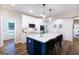 Bright open kitchen boasts white cabinets, stainless appliances, and island seating at 61 Main St, Moreland, GA 30259
