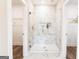 Modern walk-in shower featuring beautiful marble-look tile and glass door at 61 Main St, Moreland, GA 30259