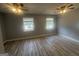 Bedroom with wood-look flooring, neutral walls, and two windows allowing natural light at 8427 Fredericksburg Ct, Jonesboro, GA 30238