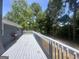 View of the large deck with gray wood flooring, surrounded by lush trees at 8427 Fredericksburg Ct, Jonesboro, GA 30238