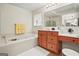 Bathroom with jetted tub, cherry-stained vanity, and a makeup area; offering relaxation and functionality at 3688 Eagles Beek Cir, Lithonia, GA 30038