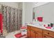 Bathroom with a single sink vanity, patterned shower curtain, and red accents throughout at 3688 Eagles Beek Cir, Lithonia, GA 30038