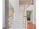 Bright foyer featuring a carpeted staircase, hardwood flooring and white trim at 3688 Eagles Beek Cir, Lithonia, GA 30038