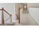 Well-lit hallway with carpet, white walls, and wooden banister leading to the staircase at 3688 Eagles Beek Cir, Lithonia, GA 30038