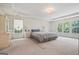 Spacious bedroom with large windows, light carpet, and tray ceiling allowing for natural light at 3688 Eagles Beek Cir, Lithonia, GA 30038
