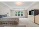 Bright main bedroom featuring large windows, a tray ceiling, and a cozy, inviting atmosphere at 3688 Eagles Beek Cir, Lithonia, GA 30038