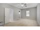 Spacious bedroom with neutral walls, carpet, fan, a window, and a walk-in closet at 871 Clearwater Rd, Sharpsburg, GA 30277