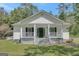 Inviting home with a quaint porch, classic white siding, and lush greenery at 871 Clearwater Rd, Sharpsburg, GA 30277