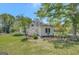 Quaint white home with a charming porch surrounded by lush greenery and a well-maintained lawn at 871 Clearwater Rd, Sharpsburg, GA 30277