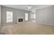 Spacious living room with fireplace, neutral walls, carpet, and natural light streaming through the windows at 871 Clearwater Rd, Sharpsburg, GA 30277