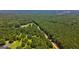 A scenic aerial view reveals a house encompassed by extensive tree cover and verdant fields at 1828 Pitts Chapel Rd, Newborn, GA 30056