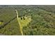 Aerial view shows the home set back on the property surrounded by woods at 1828 Pitts Chapel Rd, Newborn, GA 30056