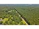 Aerial view reveals home surrounded by dense trees along a dirt driveway at 1828 Pitts Chapel Rd, Newborn, GA 30056