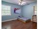 Cozy bedroom with hardwood floors, bright blue walls, and natural light from two windows at 1828 Pitts Chapel Rd, Newborn, GA 30056