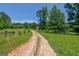 Gravel driveway leading through lush greenery to a charming country home, promising privacy and tranquility at 1828 Pitts Chapel Rd, Newborn, GA 30056