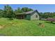 Quaint green home nestled in a lush landscape, offering a serene and private setting with mature trees and manicured lawn at 1828 Pitts Chapel Rd, Newborn, GA 30056