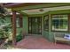 Charming front porch with natural wood door, windows, and bench, providing a welcoming entry at 1828 Pitts Chapel Rd, Newborn, GA 30056
