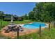 Backyard pool surrounded by trees and lush green grass with a picnic table and chairs for outdoor entertaining at 1828 Pitts Chapel Rd, Newborn, GA 30056