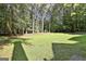 Large, well-maintained backyard featuring lush green grass and mature trees at 1202 Loxley Cir, Peachtree City, GA 30269