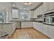 Bright kitchen with stainless steel appliances, granite counters, and wooden floors at 1202 Loxley Cir, Peachtree City, GA 30269