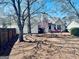 Exterior view of a charming home with a backyard, patio seating, and mature trees at 486 Village Cir, Stockbridge, GA 30281